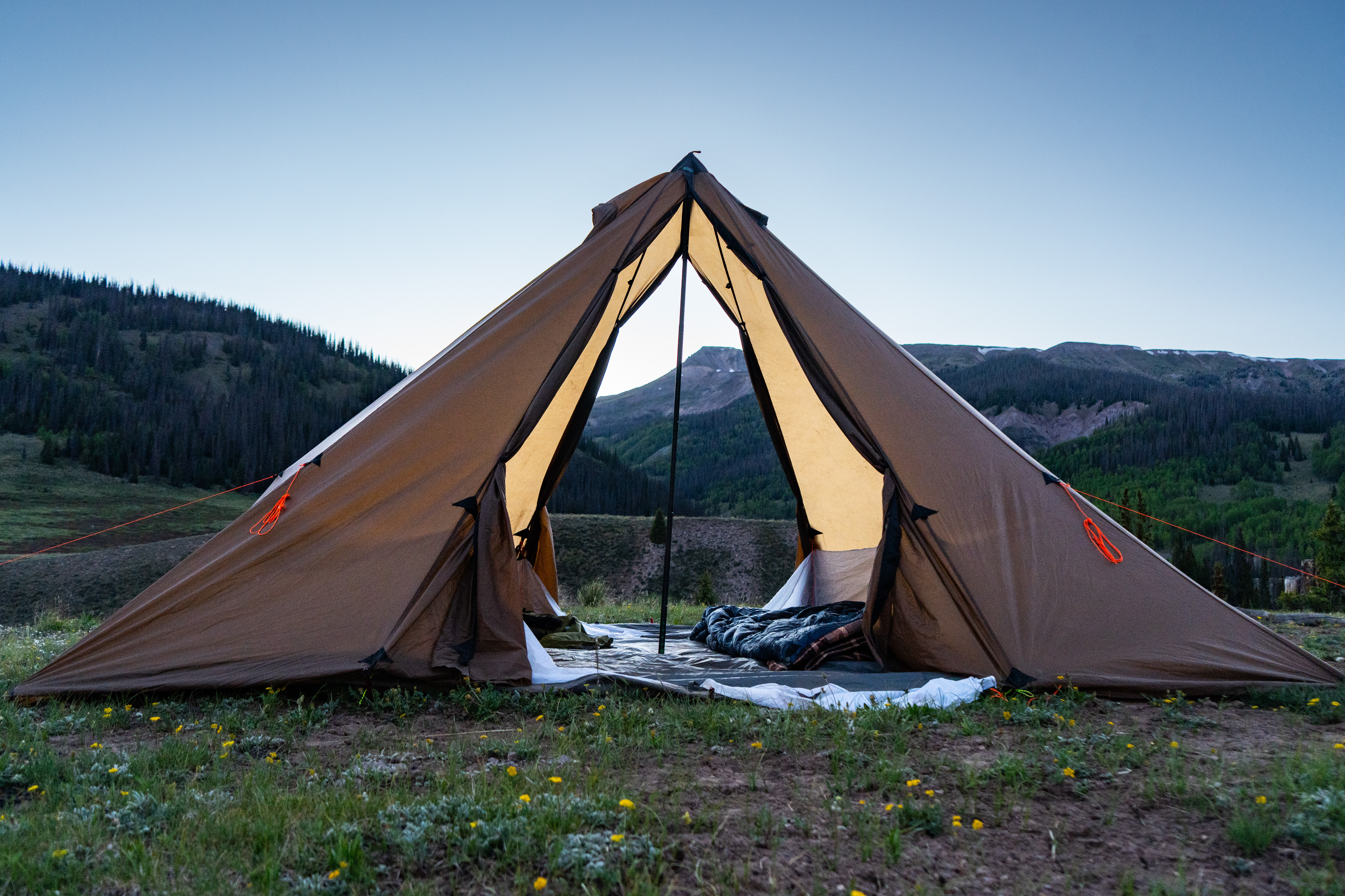 Redcliff 6 person tipi in brown color with both doors open, the redcliff has the floor liner system installed and the bathtub walls are protecting the shelter from drafts