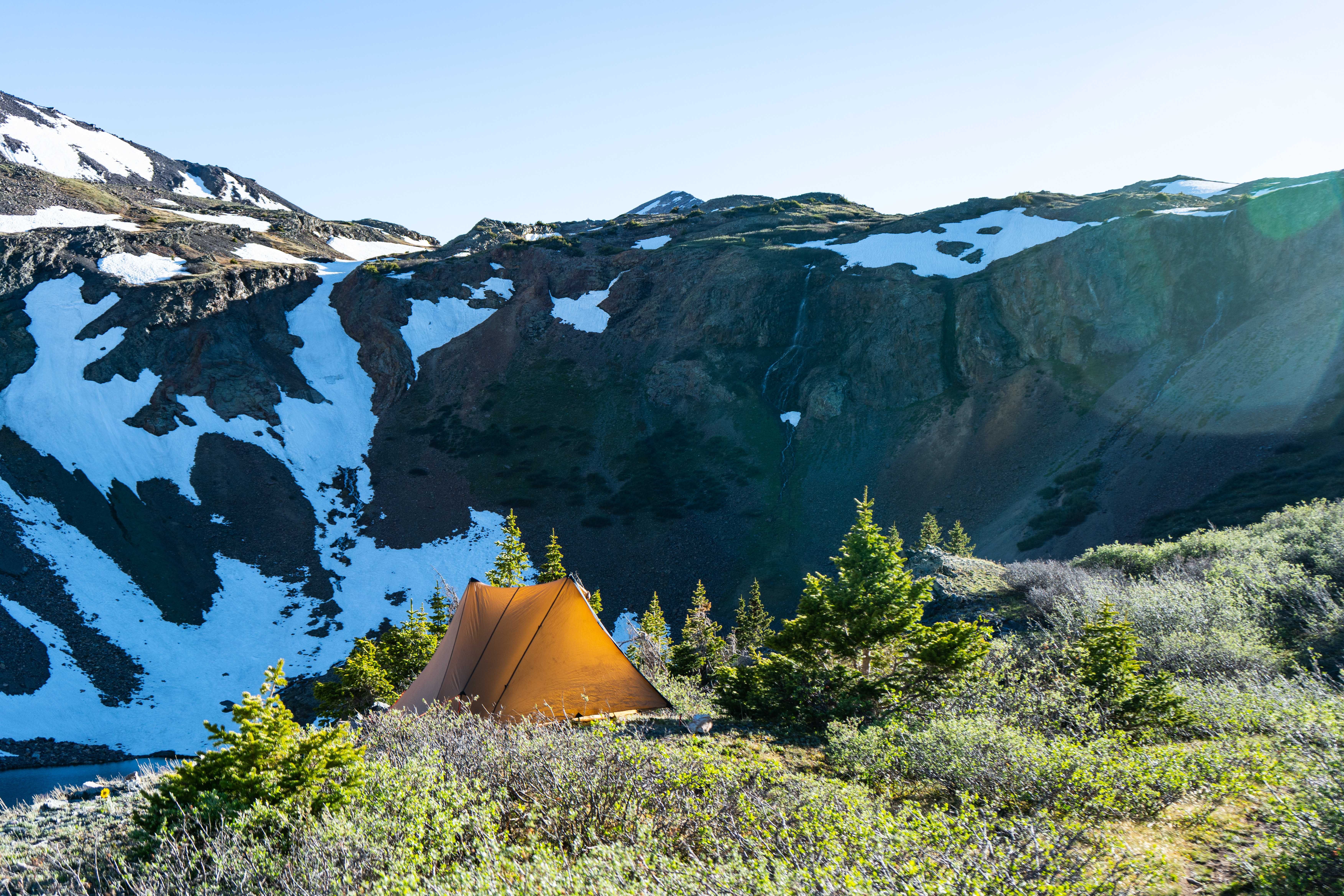 The Silex 2.0 in brown color on an escapment in the tall colorado rockie mountains sorounded by snow capped peaks